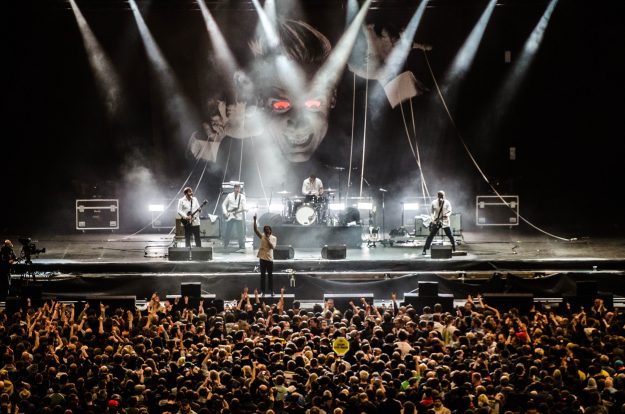 Bändi lavalla yleisön edessä.